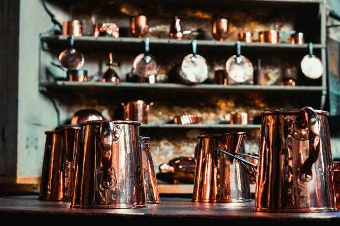 a bunch of copper cups sitting on top of a table